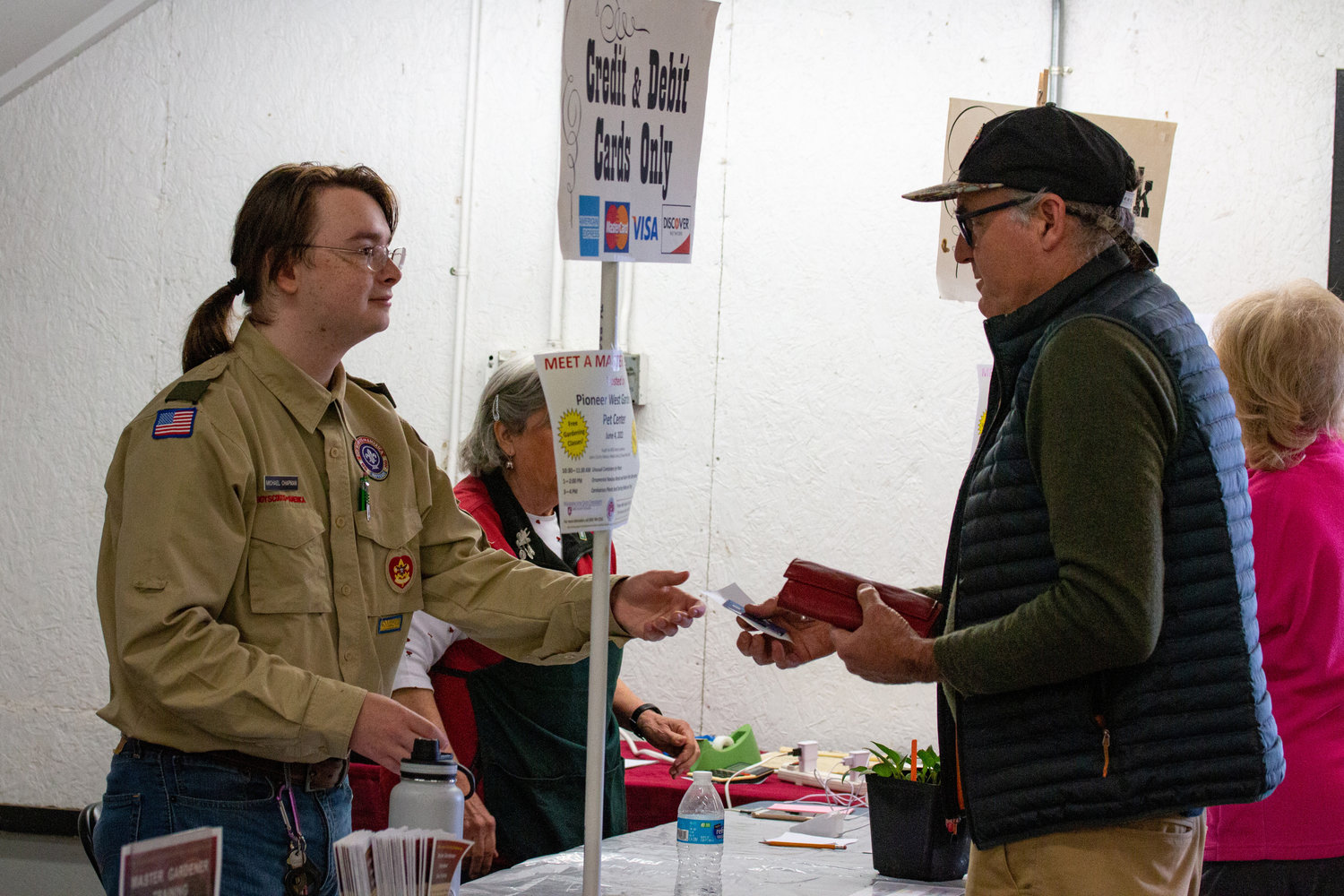 A Boy Scout accepts payment at the Master Gardener Plant Sale at the Southwest Washington Fairgrounds.